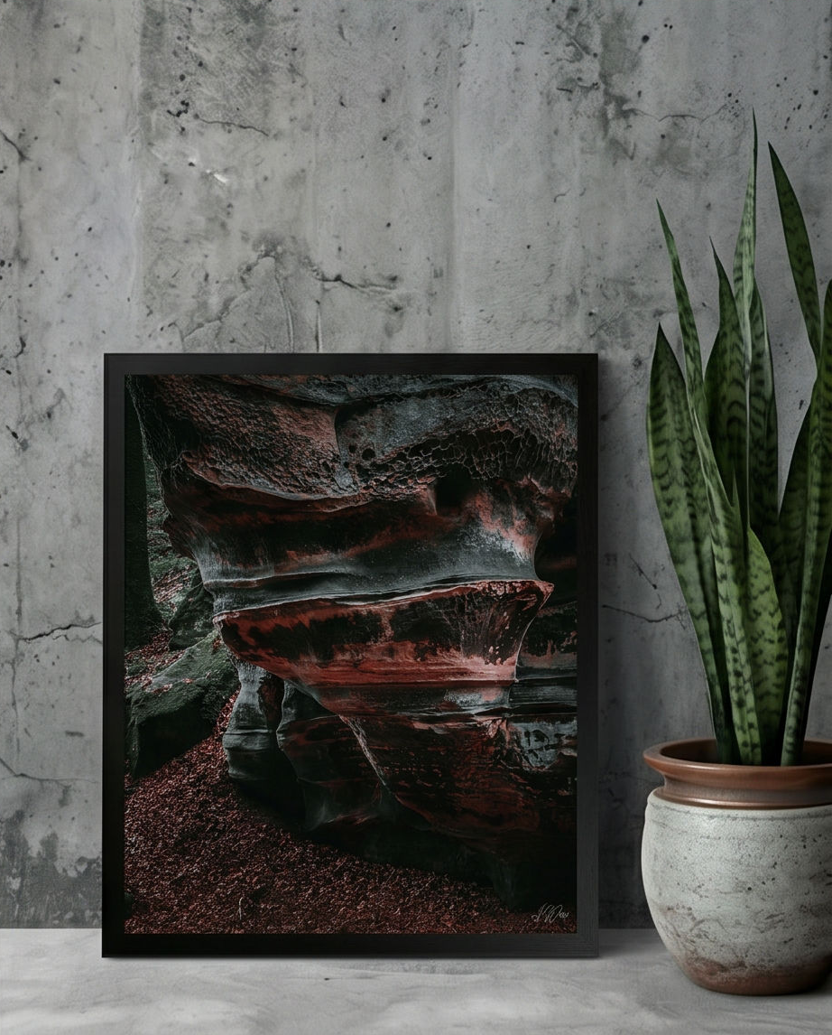 Der Lavafelsen – Gerahmter Kunstdruck an Betonwand gelehnt neben Sansevieria-Pflanze im Keramiktopf, Querformat Größenvergleich 50x70 cm
