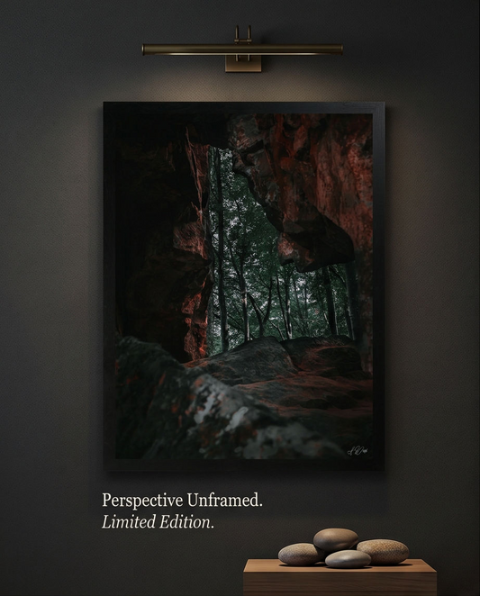 Das Steinfenster – Gerahmter Kunstdruck an dunkelgrauer Wand mit Bildleuchte, Hochformat, Höhlenblick in Wald