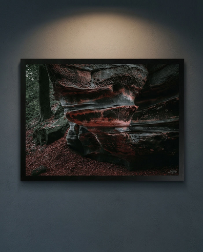 Der Lavafelsen – Gerahmter Kunstdruck an dunkelgrauer Wand mit Deckenstrahler, Querformat, roter Sandstein mit Wabenstruktur