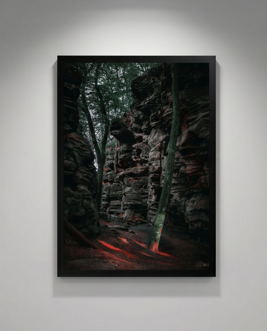 Felsweg – Gerahmter Kunstdruck an hellgrauer Galeriewand mit Deckenstrahler, Hochformat, dunkle Sandsteinfelsen