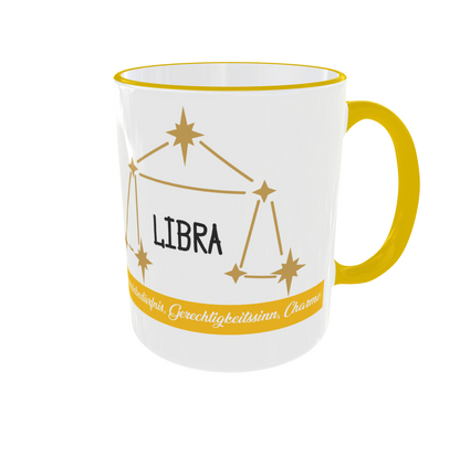 Weiße Keramiktasse mit gelbem Henkel zeigt die Sternbild-Konstellation der Waage und den Schriftzug Libra.
