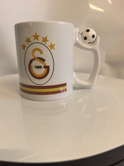 Galatasaray Tasse mit offiziellem Vereins-Logo (GS 1905, 5 Sterne) und Fußball am Griff.
