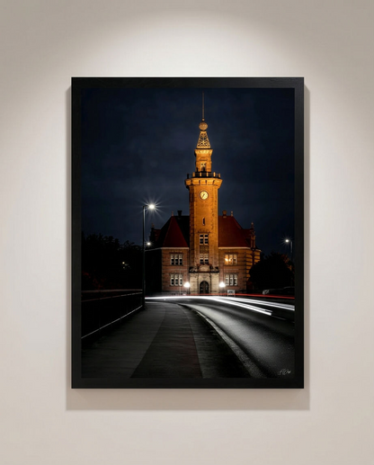 Hafenamt bei Nacht – Gerahmter Kunstdruck an heller Wand, Hochformat, goldener Uhrenturm mit weißen und roten Lichtspuren