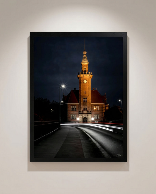 Hafenamt bei Nacht – Gerahmter Kunstdruck an heller Wand, Hochformat, goldener Uhrenturm mit weißen und roten Lichtspuren