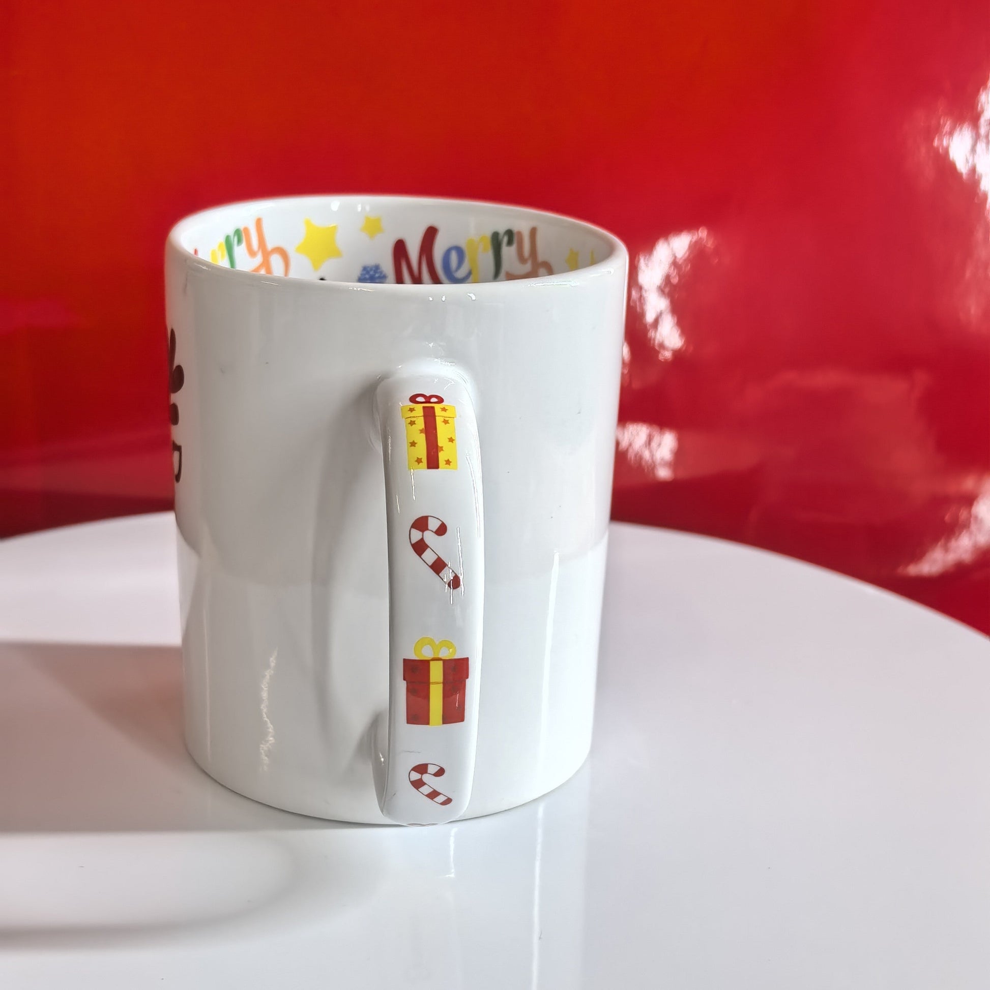 Henkel der Weihnachtstasse mit Geschenken und Zuckerstangen als Akzent.