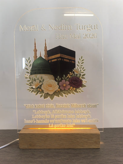 Personalisiertes Pilgerfahrt Acrylglas mit LED-Holzsockel auf hellem Hintergrund, Kaaba und Moschee-Motiv mit Blumendekoration, gravierte Namen und Talbiyya-Gebet