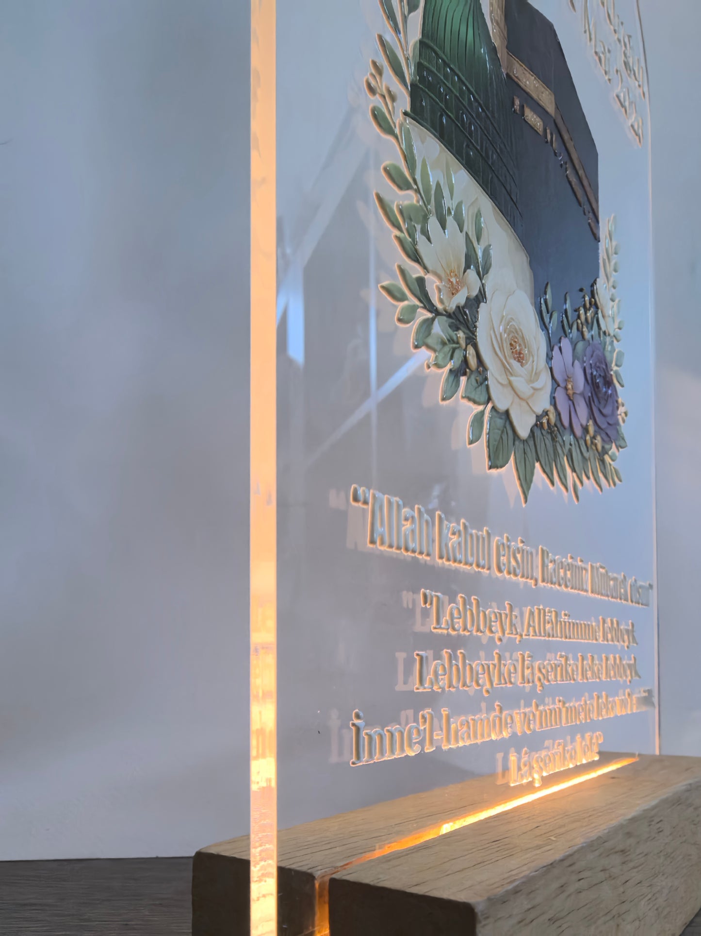 Detailaufnahme Seitenansicht Hac Acrylglas mit leuchtendem LED-Holzsockel, graviertes Talbiyya-Gebet und Blumenmotiv, warmweißes Licht