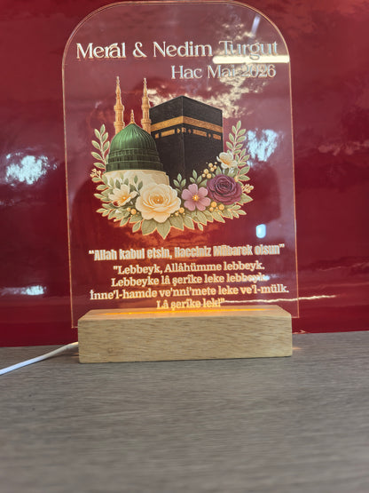 Personalisiertes Hac Acrylglas mit leuchtendem warmweißem LED-Holzsockel, Kaaba-Motiv mit Blumen, Namen und Gebet graviert, dunkler Hintergrund