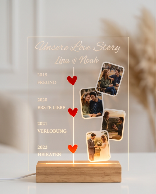 Personalisiertes Acrylglas Love Story auf Holztisch im Wohnzimmer, leuchtender LED-Holzsockel, Liebes-Timeline mit vier Meilensteinen und Paarfotos, Deko-Ambiente