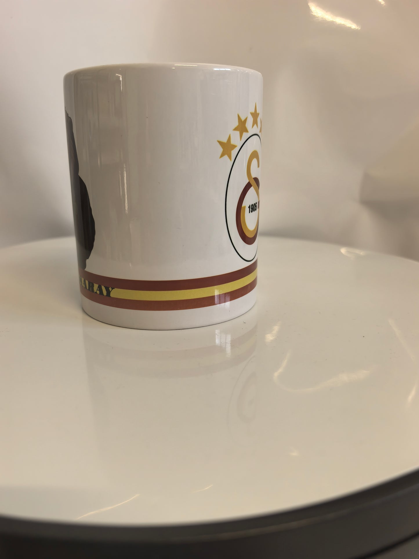 Seitenansicht der Galatasaray Tasse, die den Übergang vom Löwen-Motiv zum Logo zeigt.