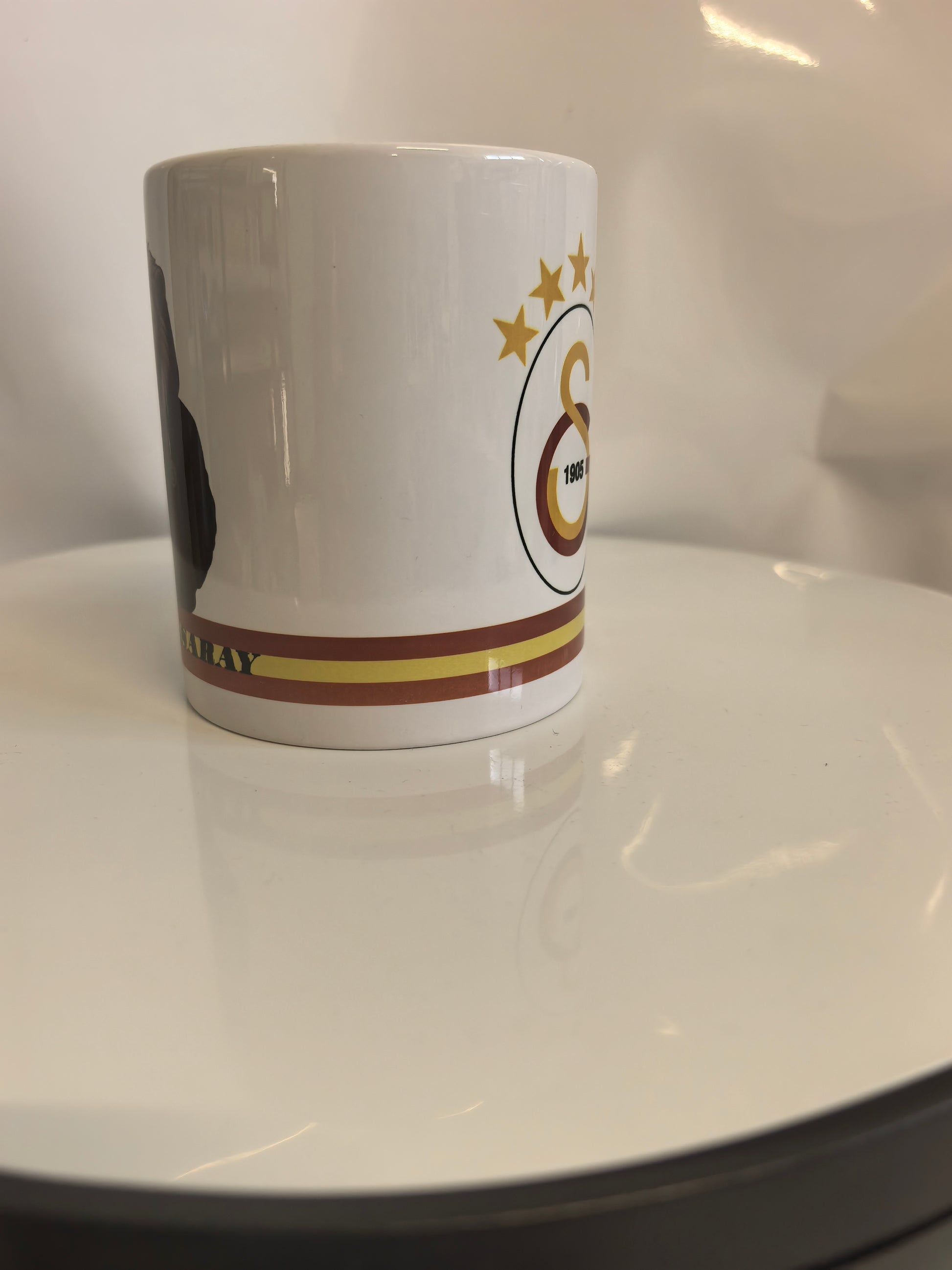 Seitenansicht der Galatasaray Tasse, die den Übergang vom Löwen-Motiv zum Logo zeigt.